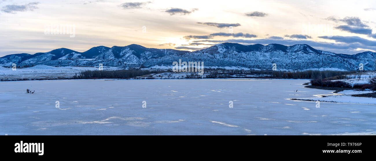 Winter Mountain Lake - A panoramic sunset view of frozen solid Bear Creek Lake at the foothill of Front Range of Rocky Mountains. Denver-Lakewood, CO. Stock Photo