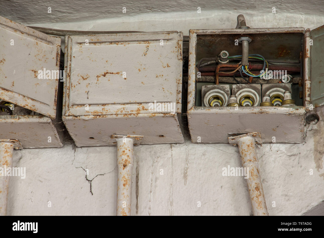 three old electrical boxes on wall Stock Photo
