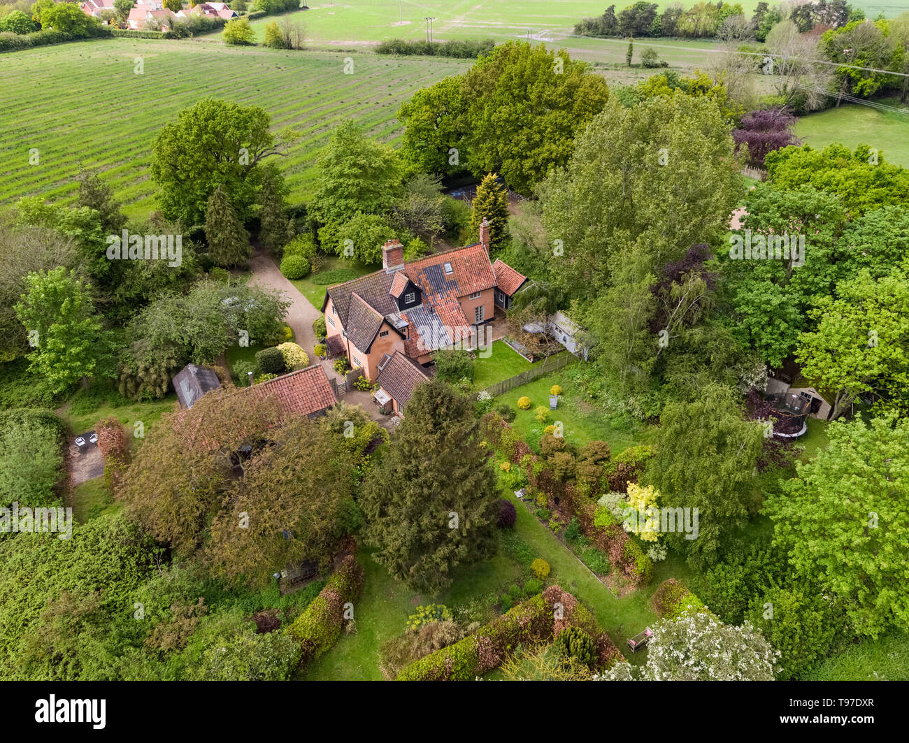 Traditional Suffolk cottage in woodland surrounded by agriculture
