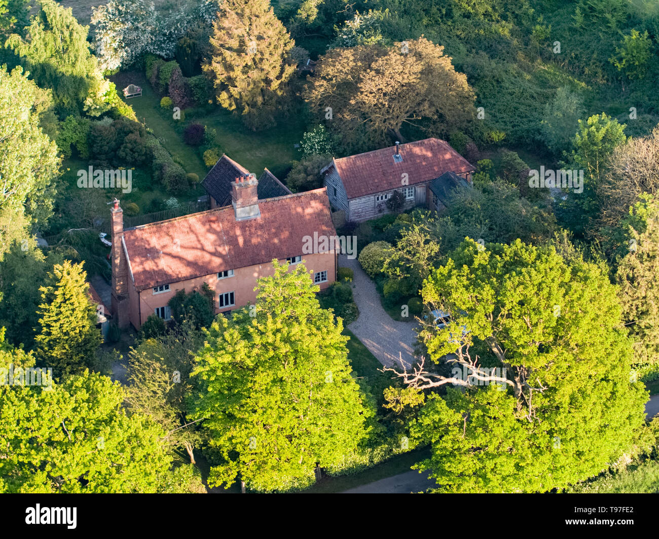 Traditional Suffolk cottage in woodland surrounded by agriculture