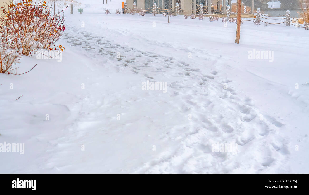 Panorama Snowy trail along Oquirrh Lake with view of a clubhouse and