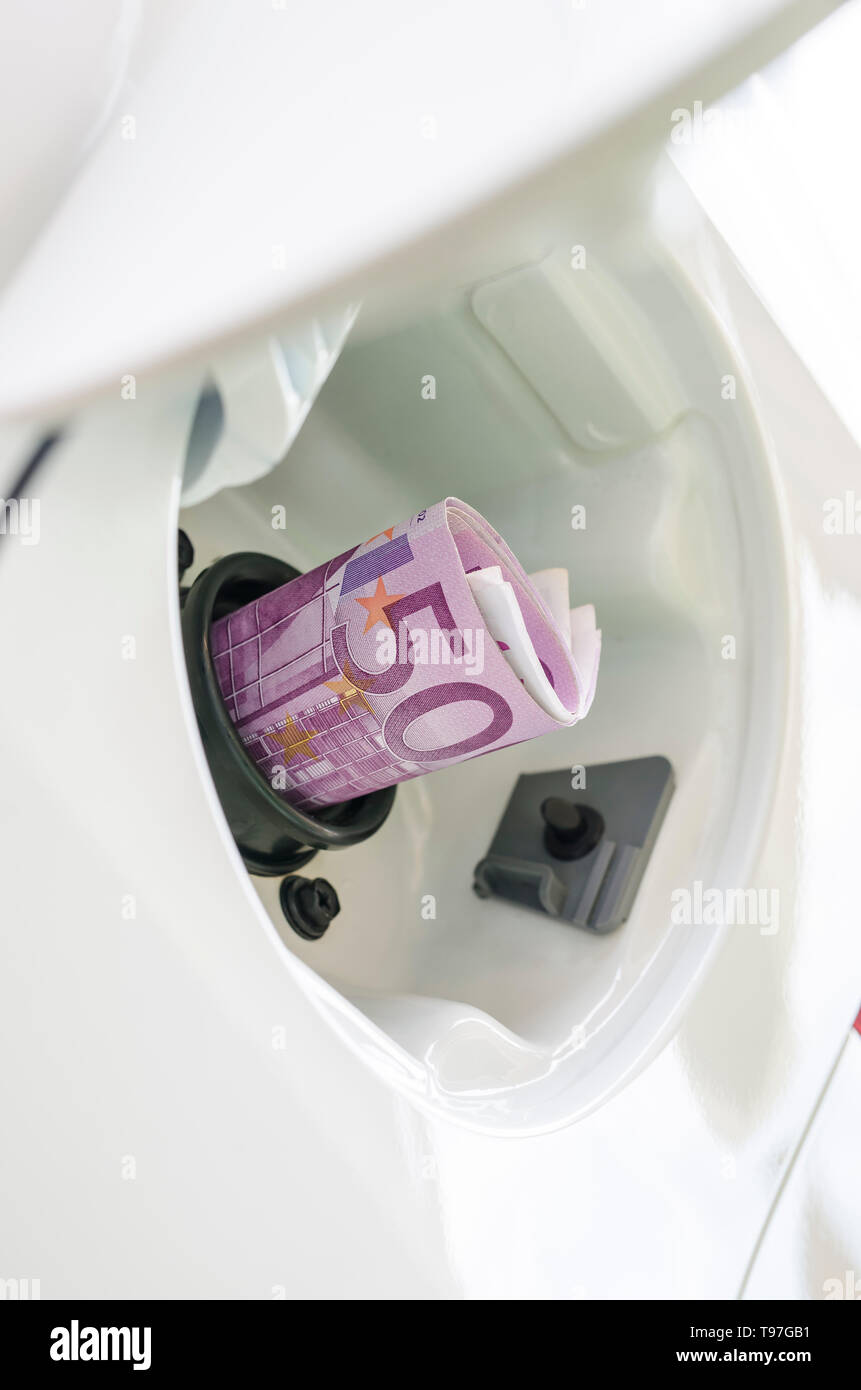 Euro money in car fuel tank opening representing expensive gas or fuel. Stock Photo
