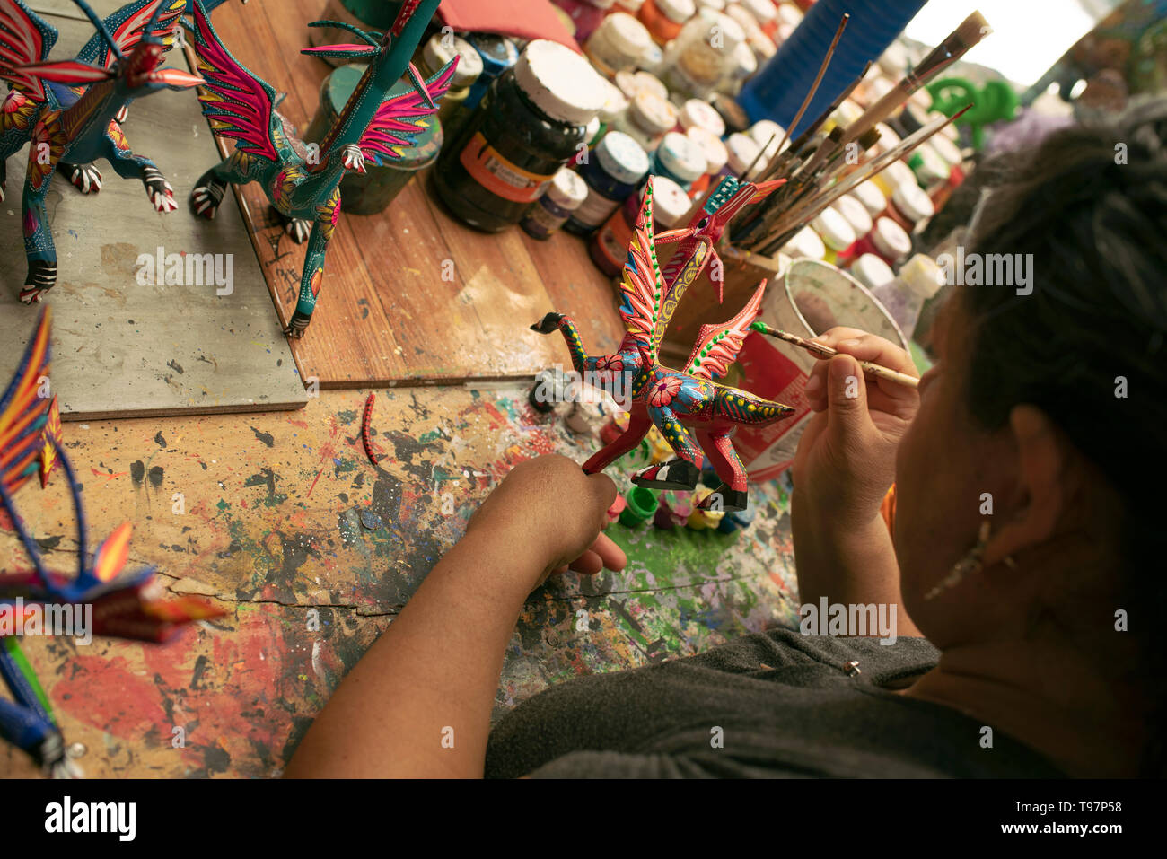 Mexican woman painting alebrijes (surreal dream-like wooden sculptures). San Martín Tilcajete, Oaxaca, Mexico. Apr 2019 Stock Photo