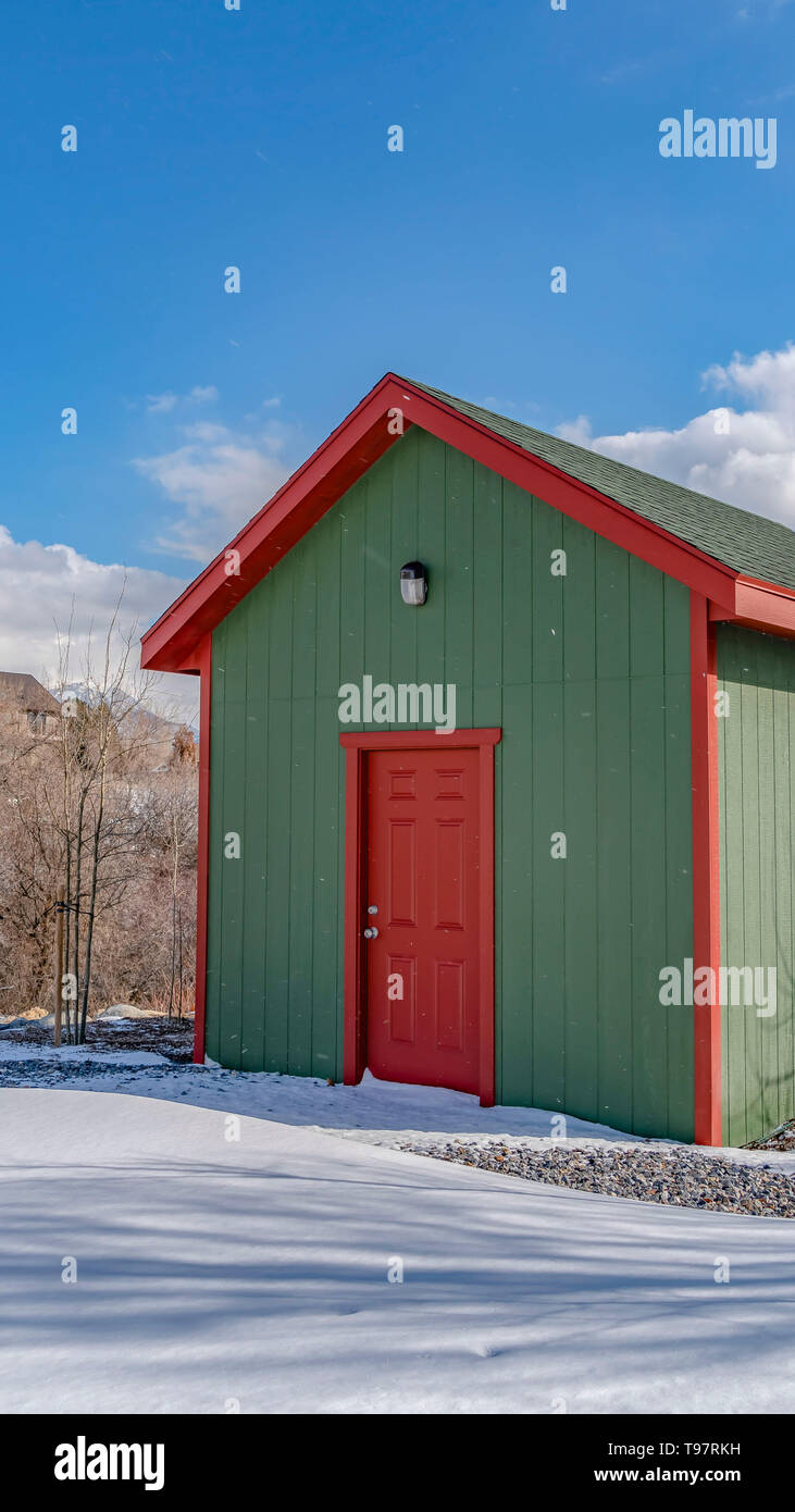 Clear Vertical Exterior of a wooden storage shed built on a snow covered ground in winter Stock Photo
