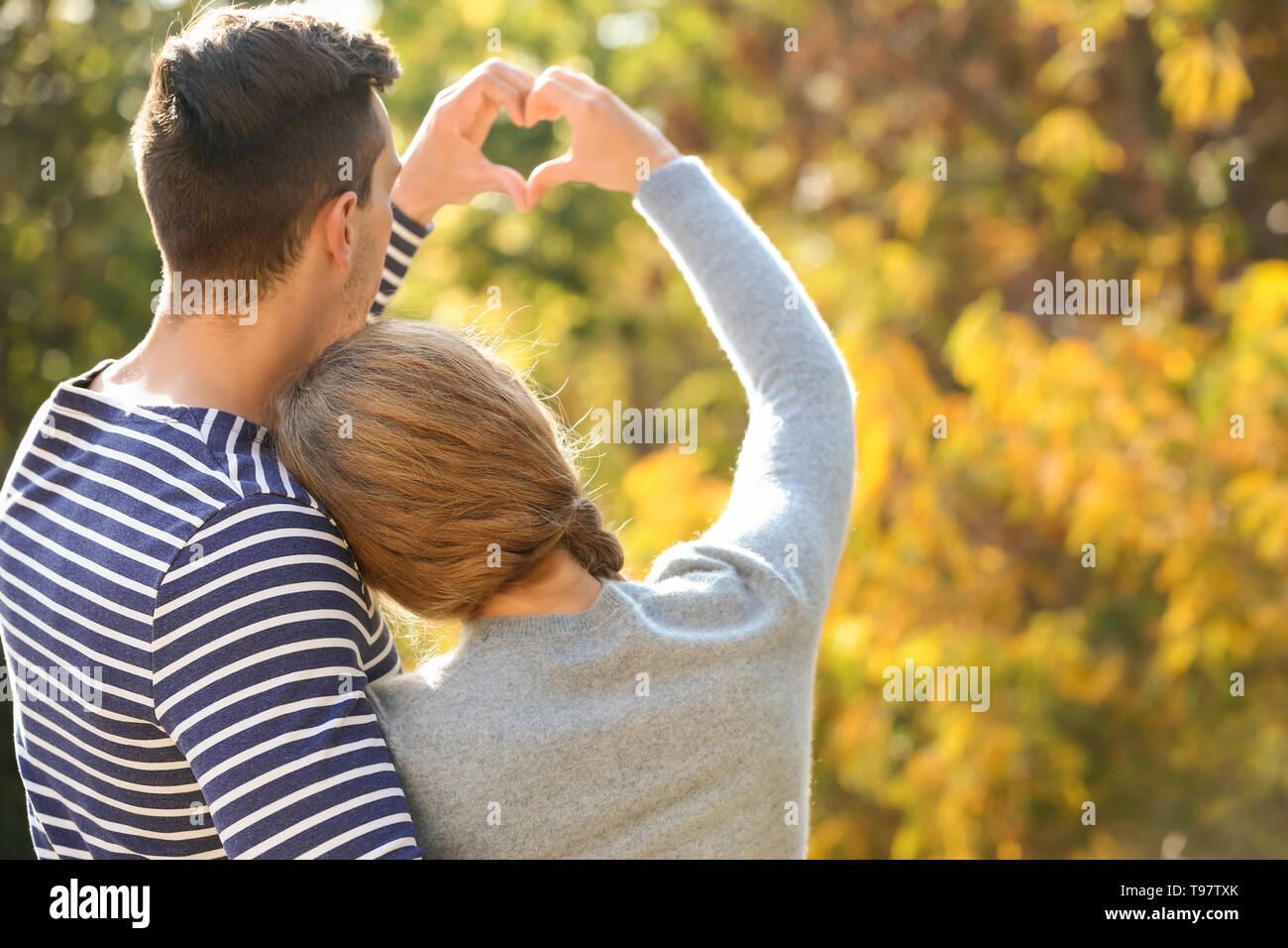 Happy couple making heart with their hands in autumn park Stock Photo ...