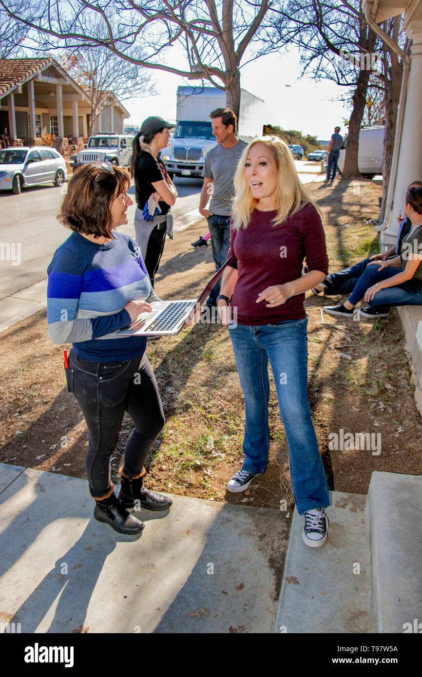 Using a laptop as a notebook, a female newspaper reporter interviews a woman in Mission Viejo