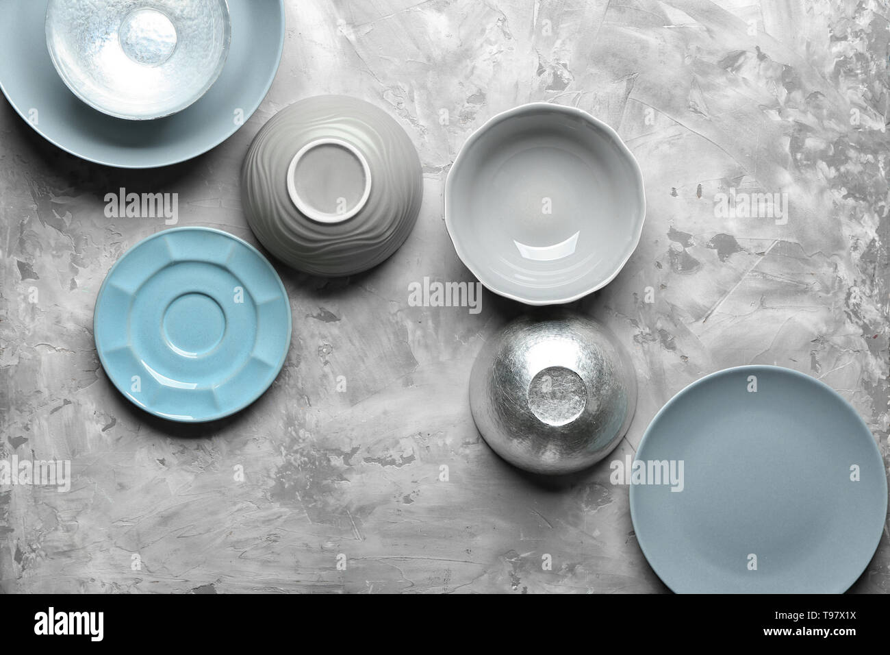 Bowls and plates on grey background Stock Photo