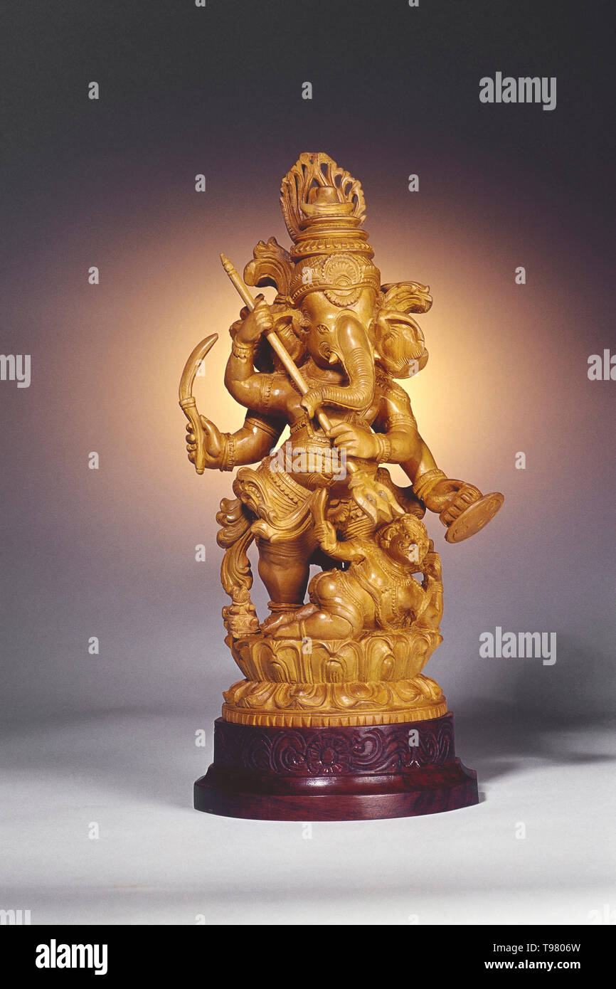 Still Life Of A Ganesh Idol Made In Sandalwood Against A Plain