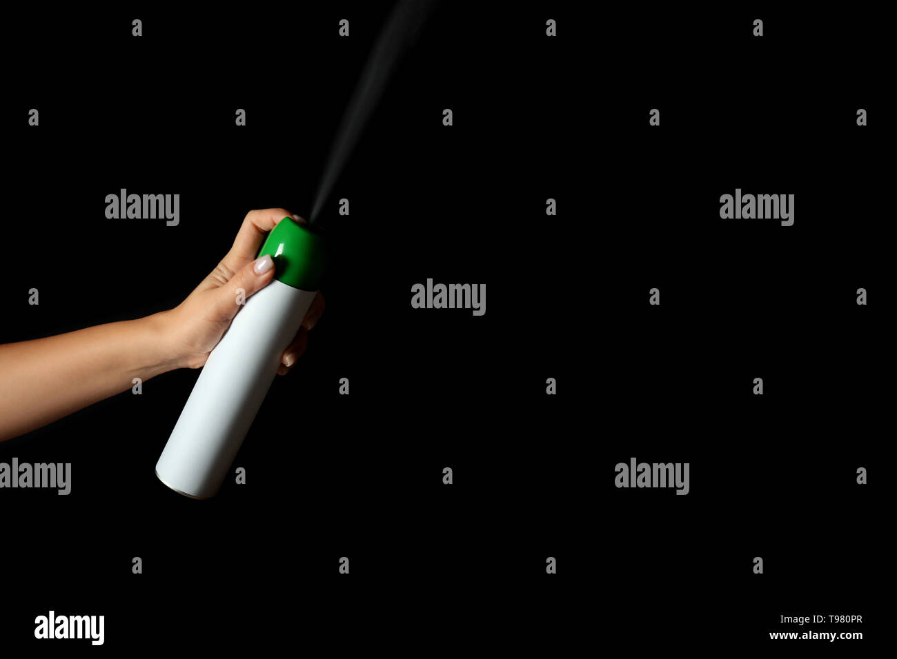 Woman spraying air freshener on dark background Stock Photo Alamy
