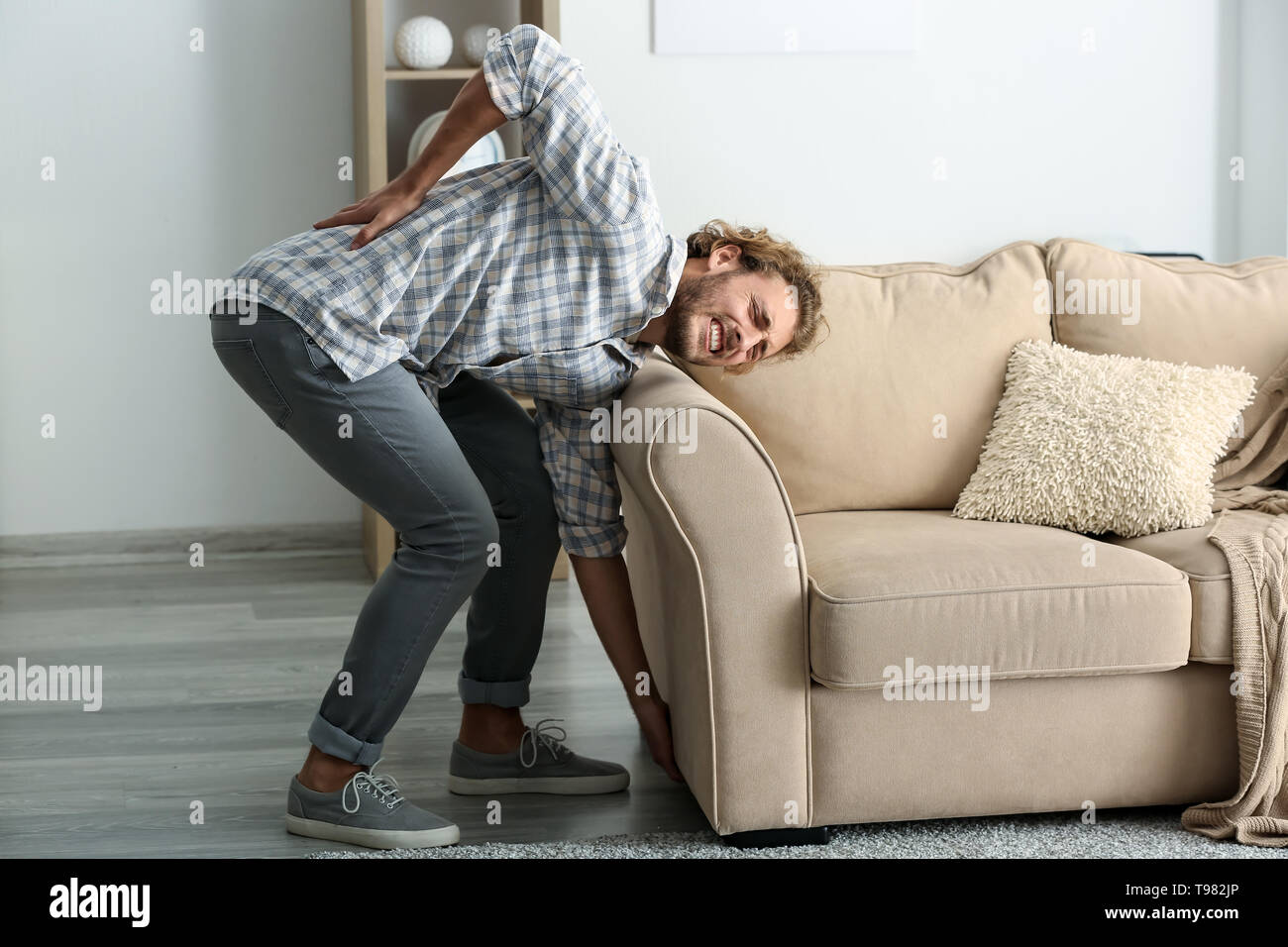 Young Man Suffering From Back Pain After Carrying Heavy Furniture