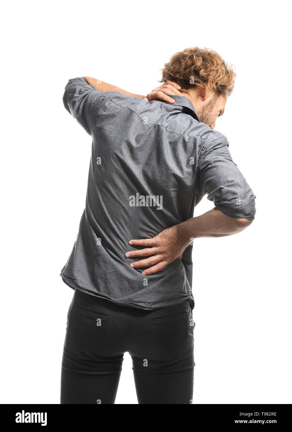 Young man suffering from back pain on white background Stock Photo - Alamy