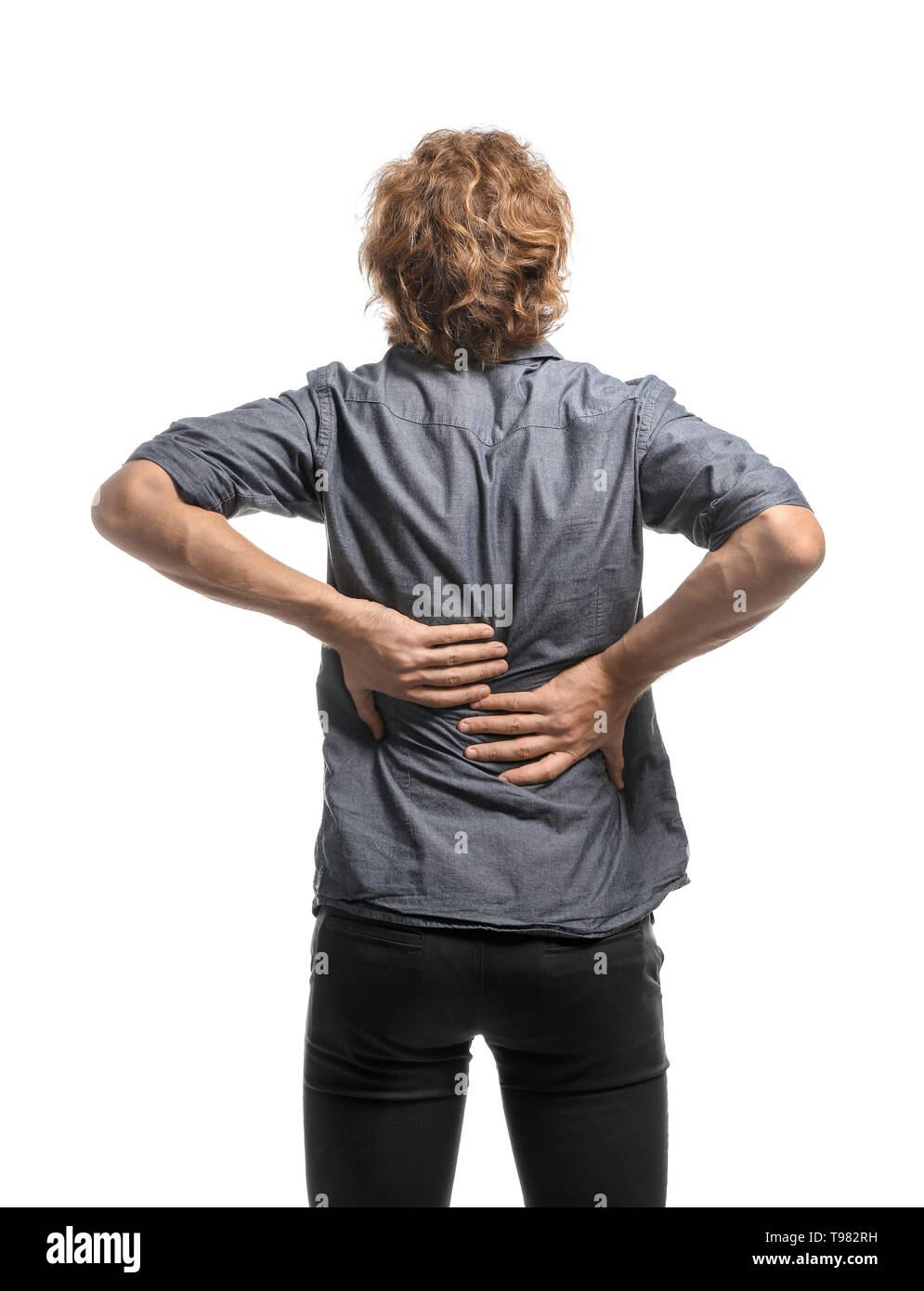 Young man suffering from back pain on white background Stock Photo - Alamy