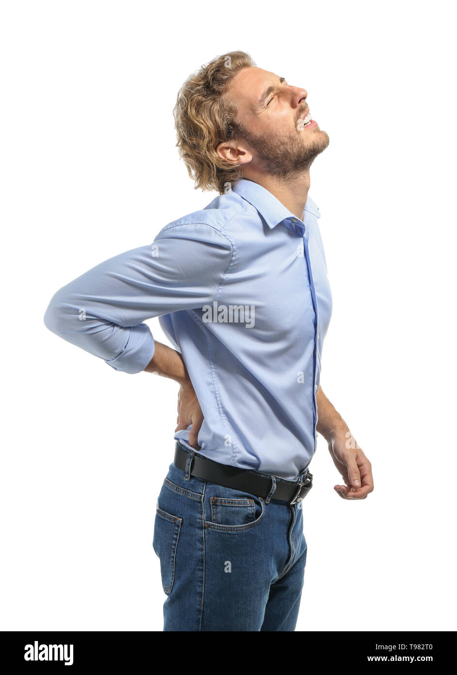 Young man suffering from back pain on white background Stock Photo - Alamy