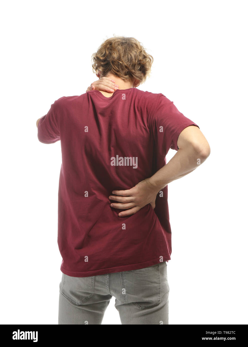 Young man suffering from back pain on white background Stock Photo - Alamy