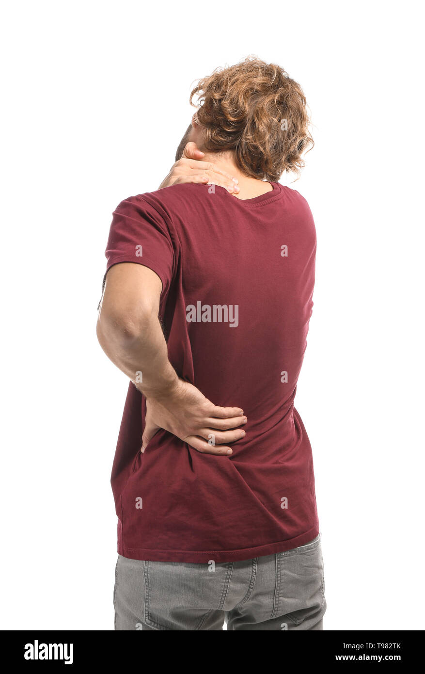 Young man suffering from back pain on white background Stock Photo - Alamy