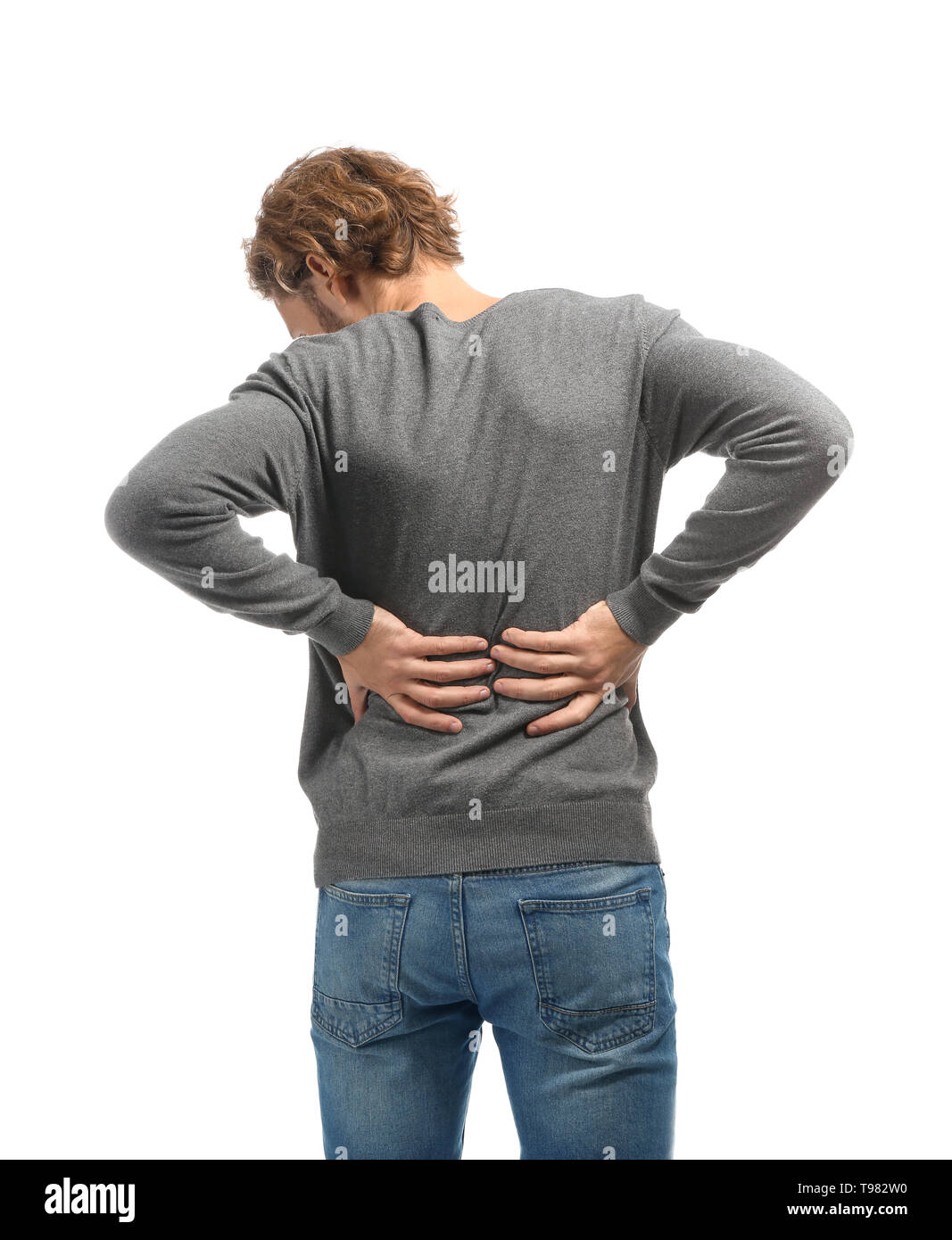 Young man suffering from back pain on white background Stock Photo - Alamy