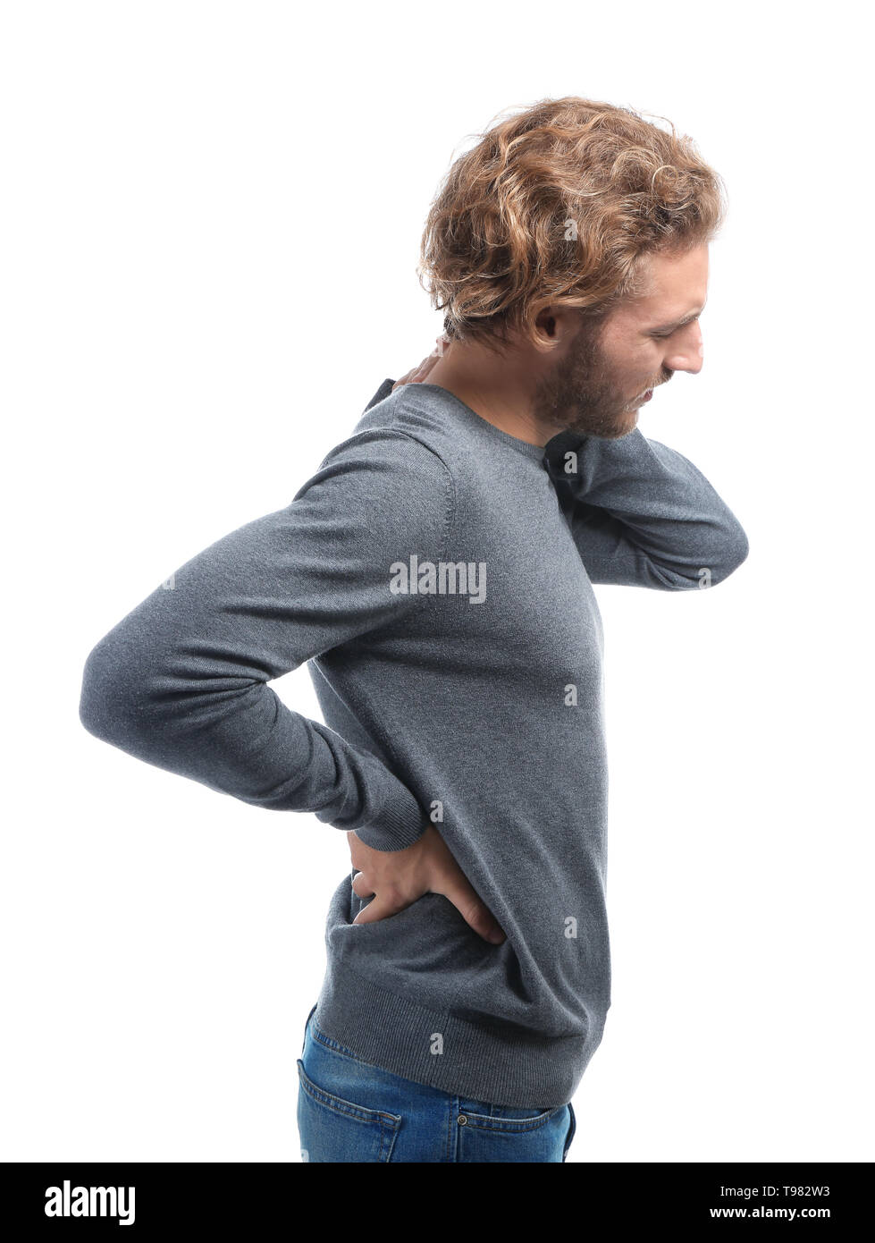 Young man suffering from back pain on white background Stock Photo - Alamy
