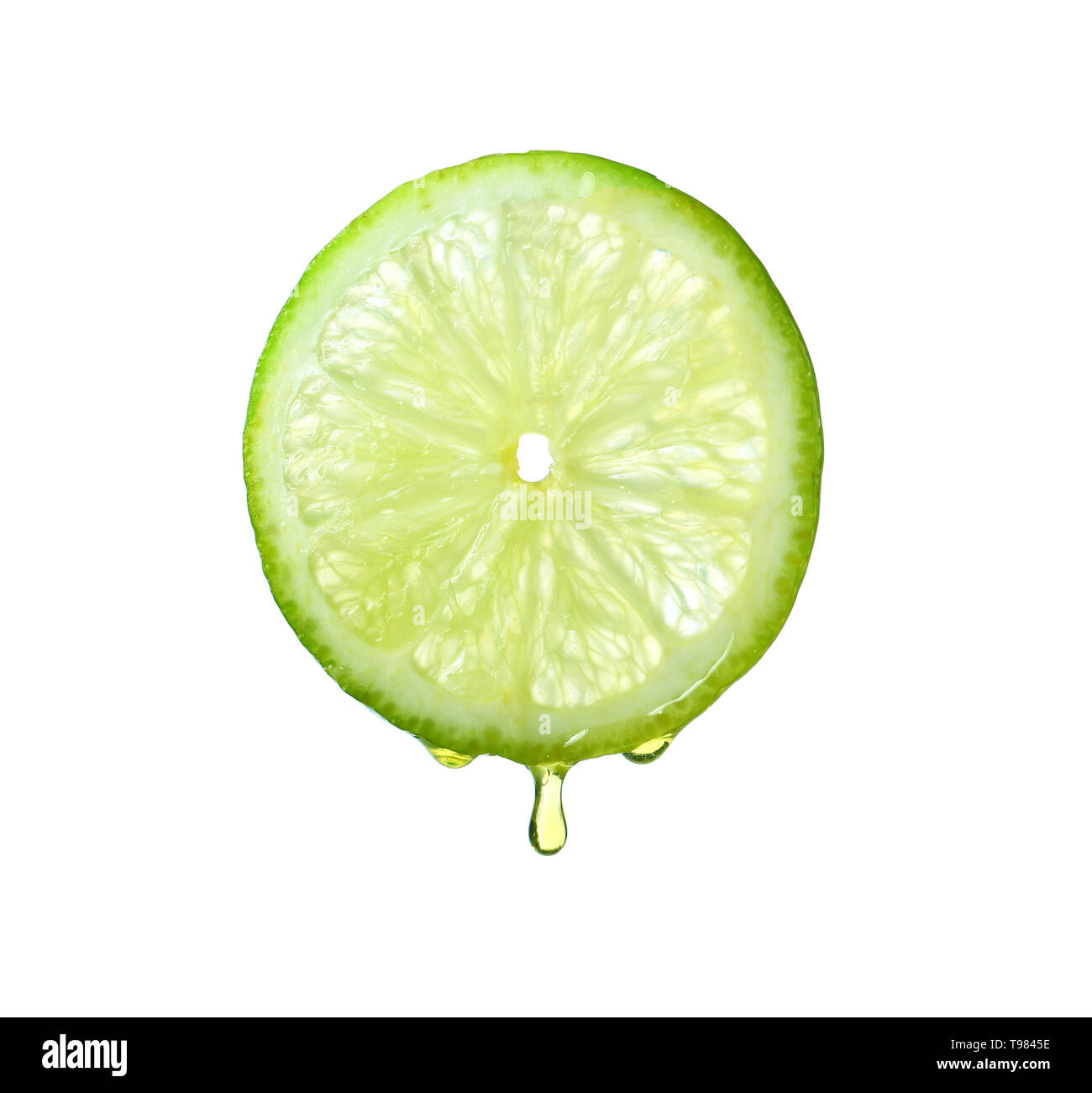 Essential oil dripping from lime slice on white background Stock Photo
