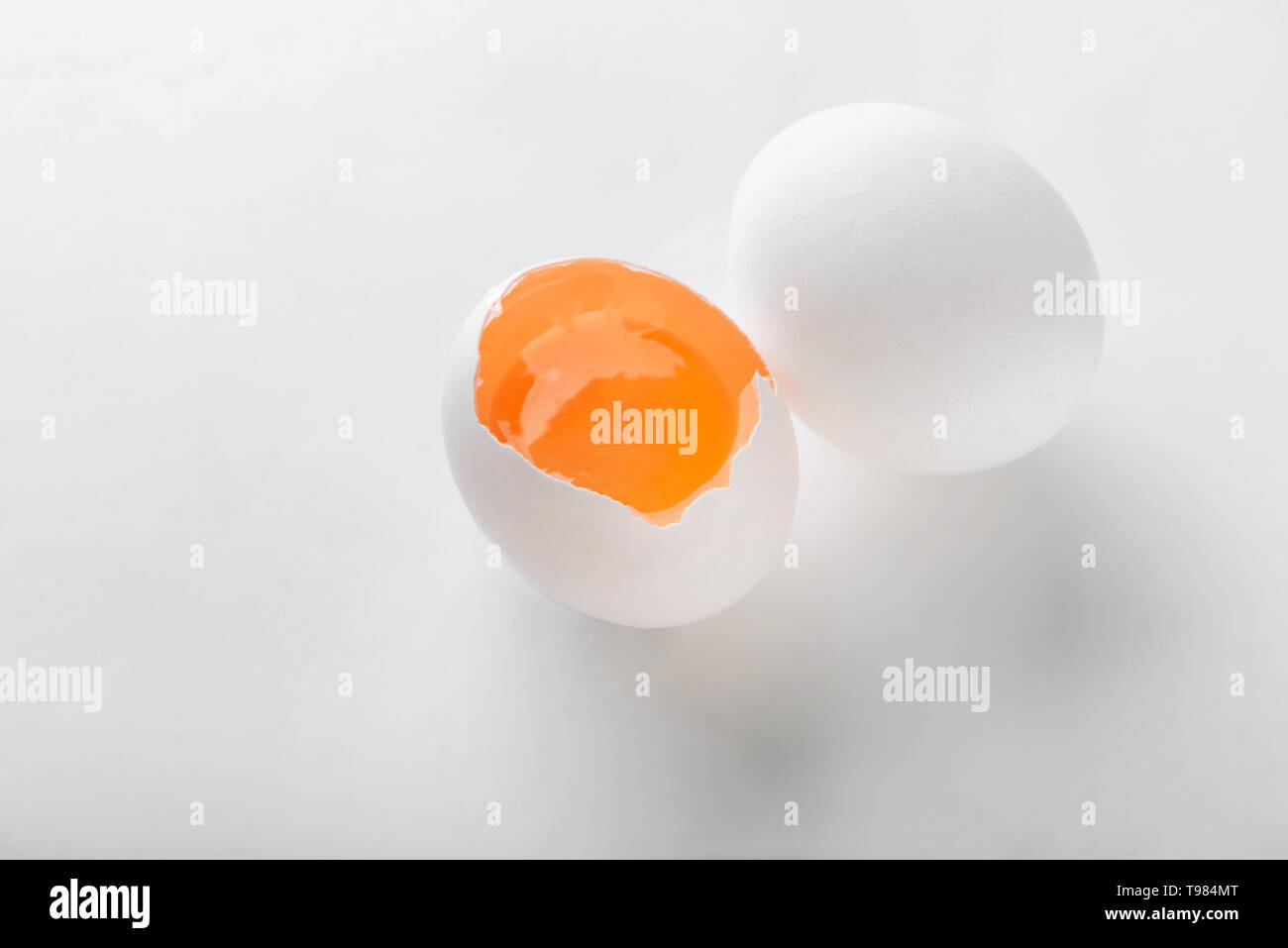 Cracked and whole chicken eggs on white background Stock Photo - Alamy