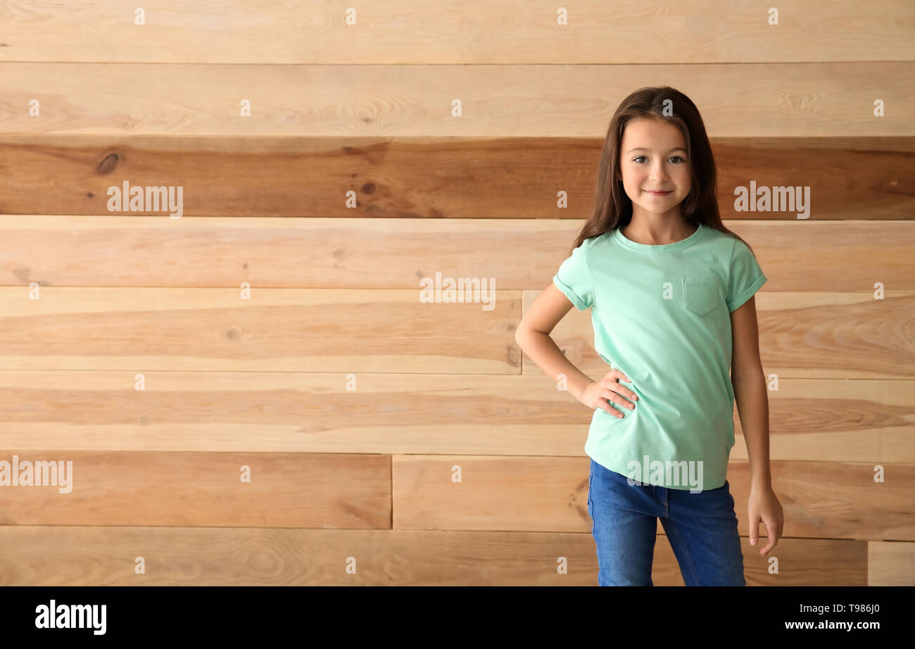 Cute girl in t-shirt on wooden background Stock Photo - Alamy