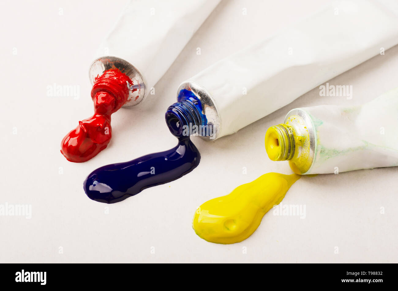 Tubes of three red, blue and yellow paint on a white background Stock Photo