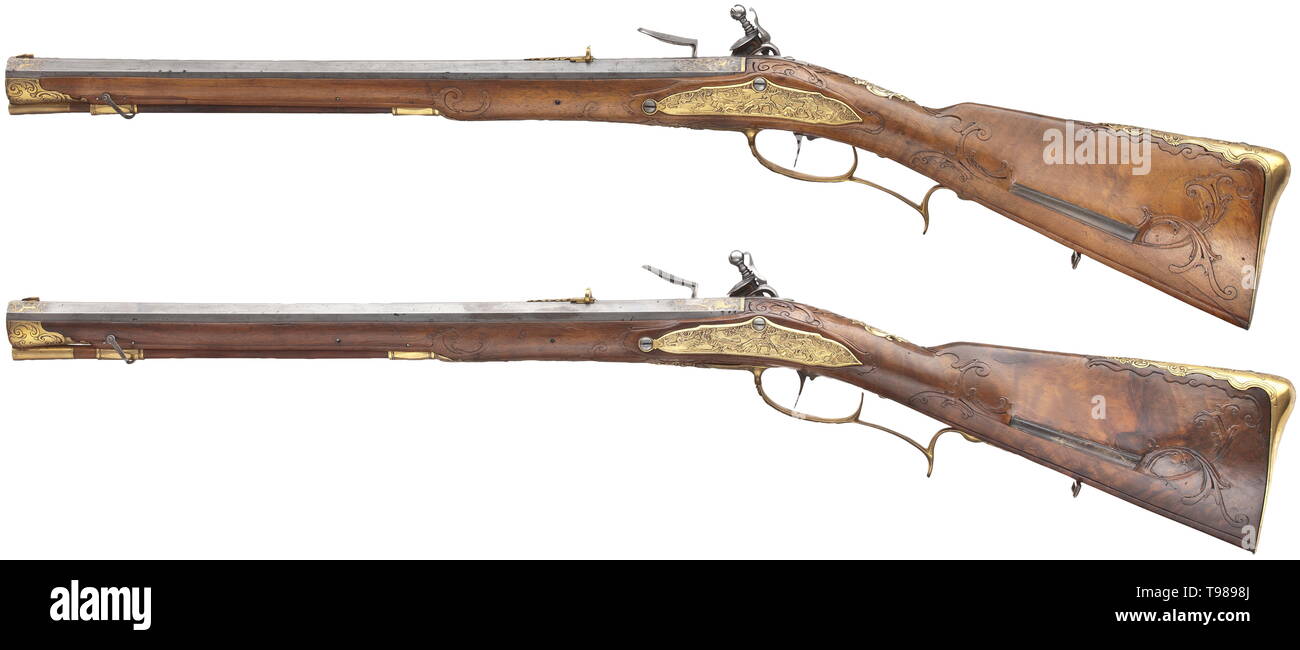 A pair of flintlock rifles, Johann Adam Knod, Karlovy Vary, circa 1740 Slightly swamped, octagonal barrels with seven-groove rifling in 14 mm calibre with dovetailed, gilded front and rear sights. The muzzles and breeches decorated with engraved and gilded ornaments. The upper sides of the barrels inscribed in (rubbed) gold inlay 'JOHANN ADAM KNOD'. Flintlocks chiselled with hunting scenes in relief. The finely carved walnut full stocks with gilded bronze furnitures decorated with hunting scenes in relief. Inscription 'V. H. GEHEIM - RATH - ZIEGE, Additional-Rights-Clearance-Info-Not-Available Stock Photo