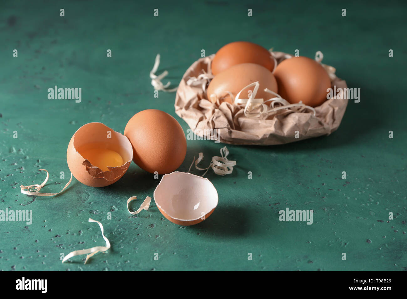 Cracked and whole chicken eggs on color table Stock Photo - Alamy