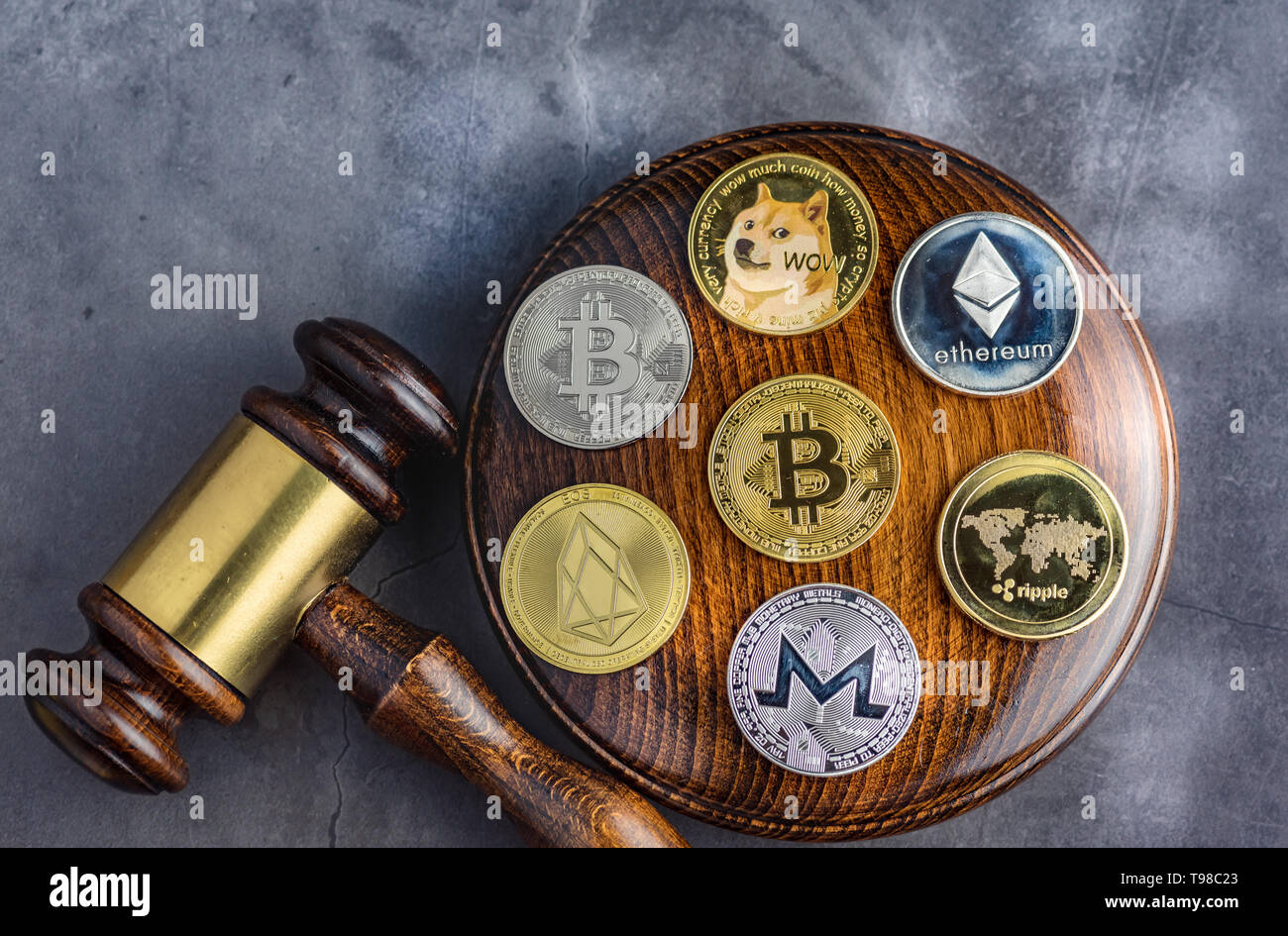 Different cryptocurrencies and gavel over gavel wooden board.Concept image for cryptocurrency Stock Photo
