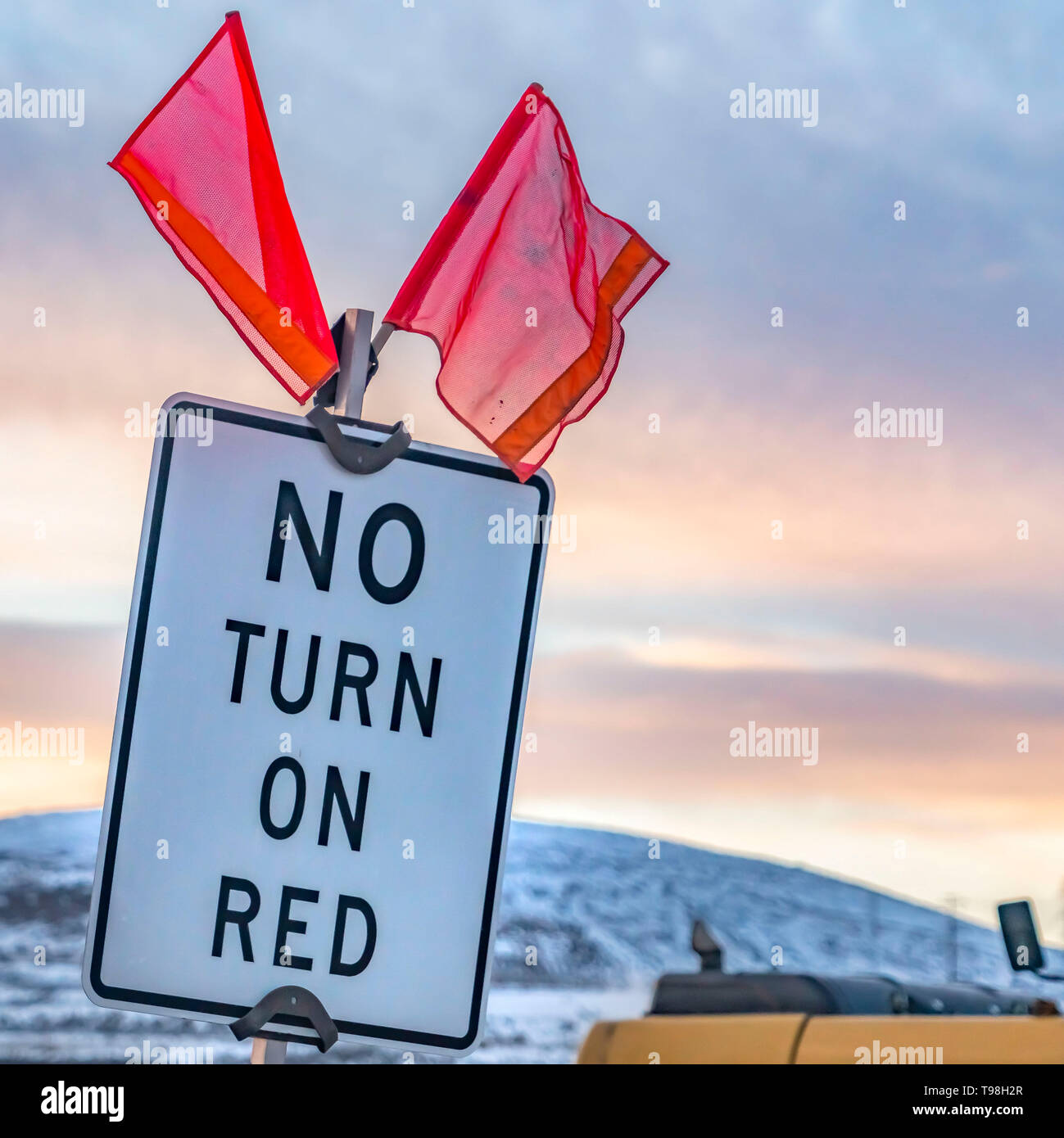 Square Close up of a No Turn On Red sign with red flags on top Stock