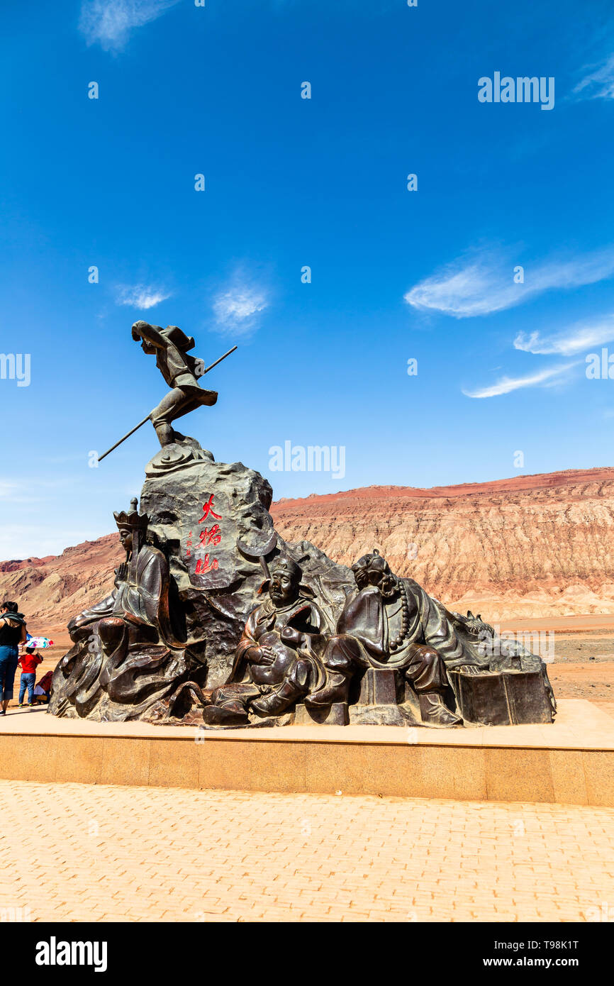 Aug 2017, Flaming Mountains, Xinjiang, China: tourists near a statue from a scene of the Chinese epic Journey to the west when the monkey king and his Stock Photo