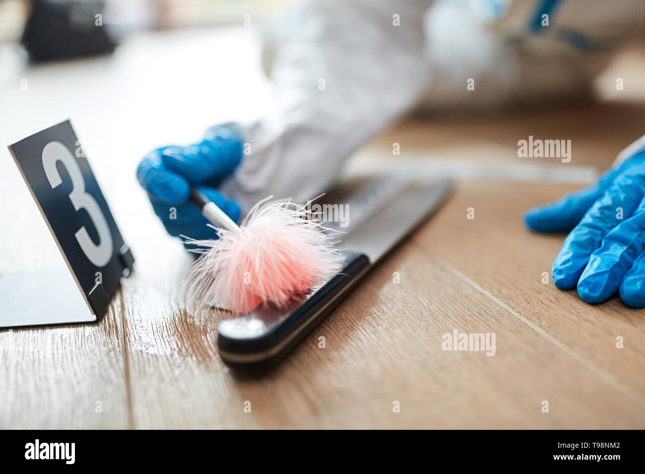 Forensic scientist looks for fingerprint on knife at a crime scene Stock Photo