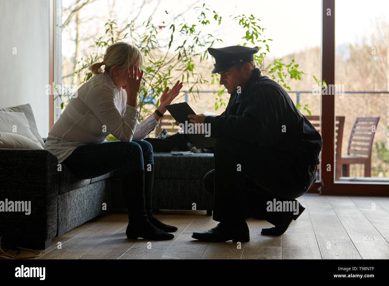 Psychologist of the police talking to a victim after a burglary with theft Stock Photo