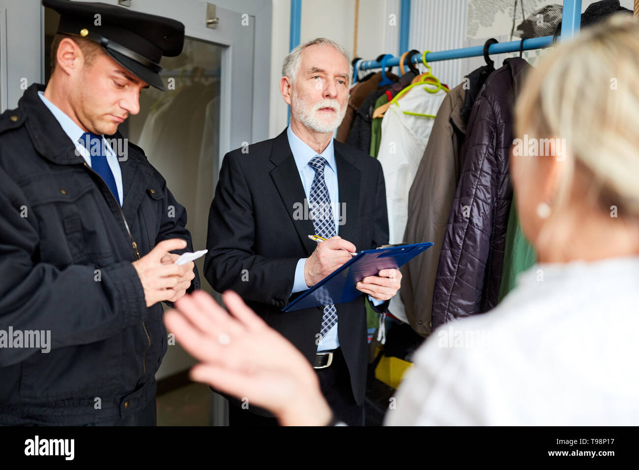 Two police officers question victims after breaking into a house at the scene Stock Photo