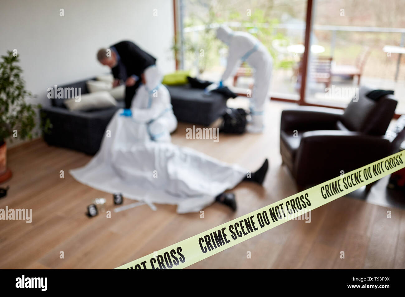 Police after murder with corpse at crime scene with forensics Stock Photo