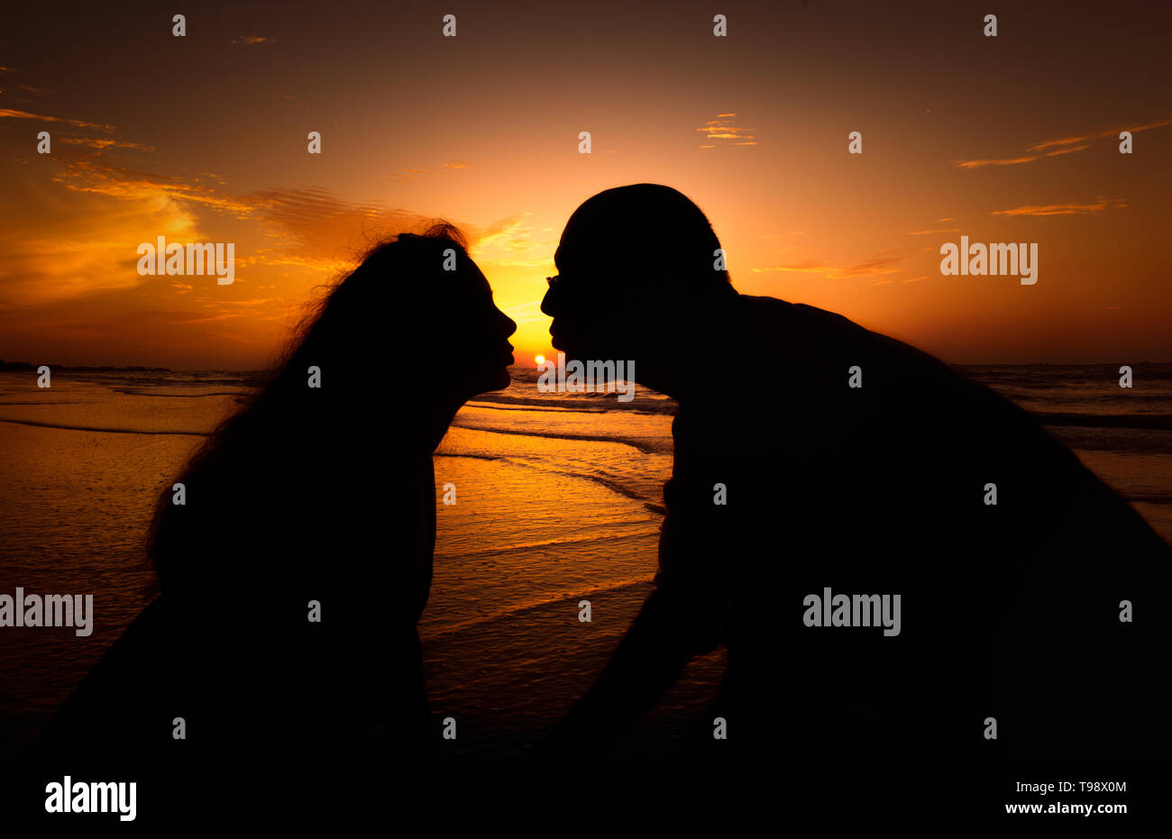Silhouette couple kissing over sunset background Stock Photo - Alamy