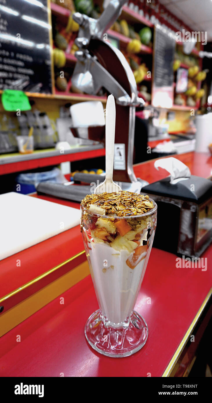 Jugos Canadå, Mexico City. Juice Bar. Tropical yogurt fruit cup with honey, granola, pineapple, papaya and other fruits on shiny red counter. Stock Photo