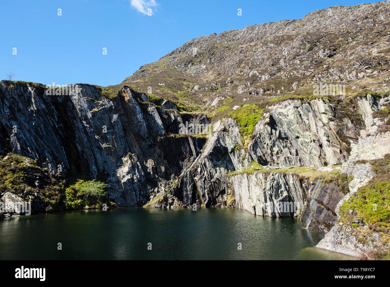 Steep sided flooded disused slate quarry pit on route to Carnedd Moel Siabod mountain in Snowdonia National Park. Capel Curig Conwy Wales UK Britain Stock Photo