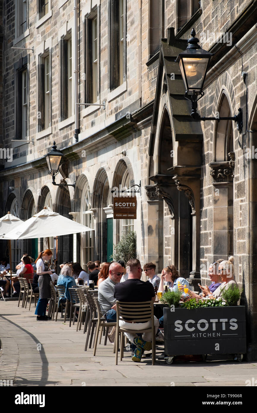 People drinking and eating in restaurants in sunny weather on Victoria Terrace above Victoria Street in Edinburgh Old Town, Scotland, UK Stock Photo