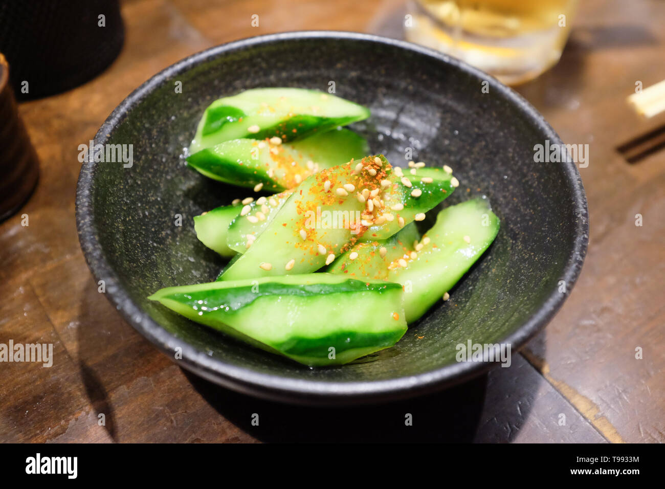 Chopped cucumber with a sprinkling of shichimi (seven spice mix) and sesame seeds. Stock Photo
