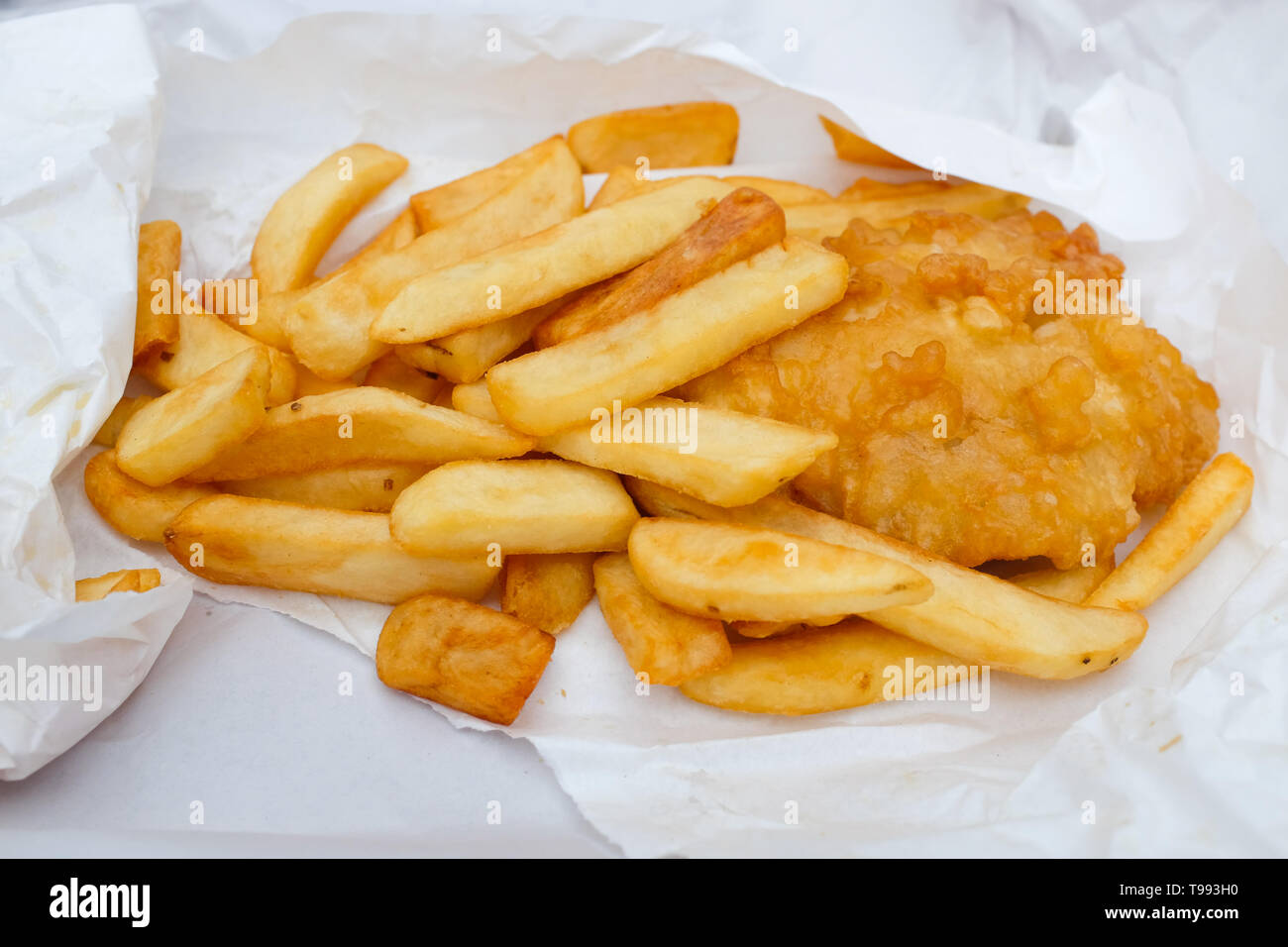 Unwrapped fish and chips. Stock Photo