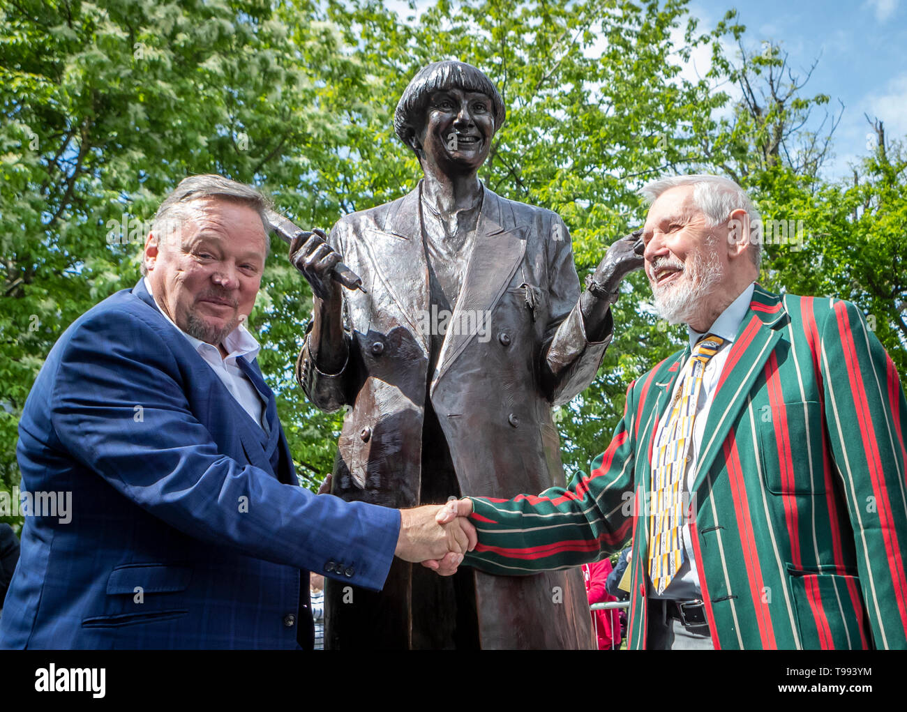 A life-size bronze statue of the late comedian, writer and actor, Victoria Wood is unveiled in Bury town centre by comedian Ted Robbins (left) and her brother Chris Foote Wood. Stock Photo
