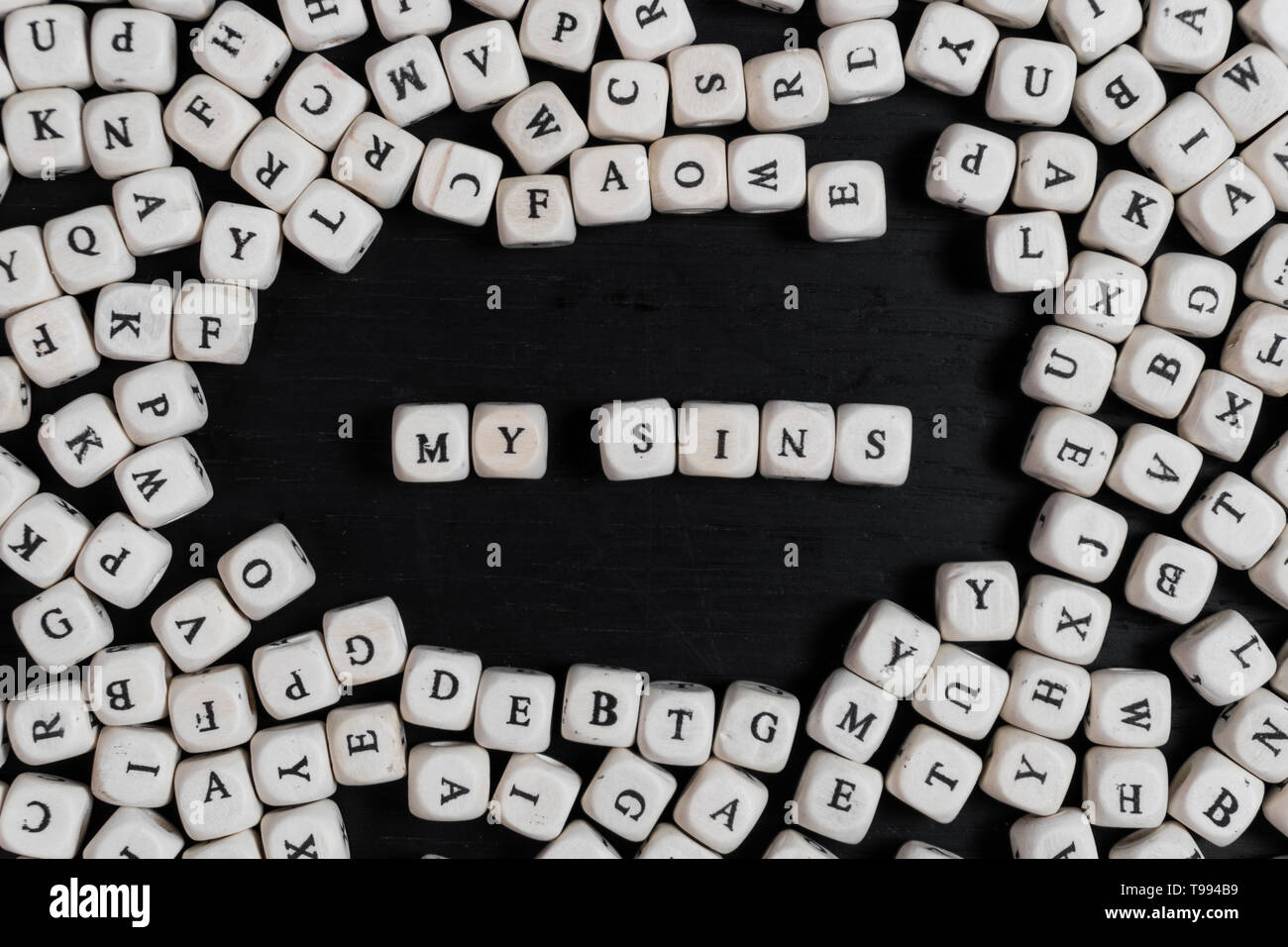 Word MY SINS on wooden cubes on a black wooden table with copy space Stock Photo