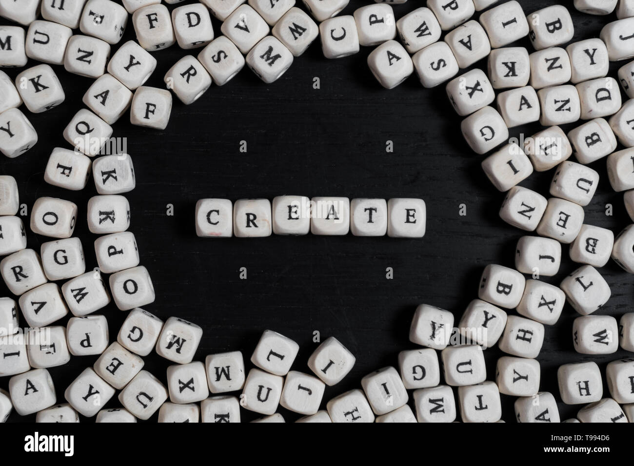 Word CREATE on wooden cubes on a black wooden table with copy space Stock Photo