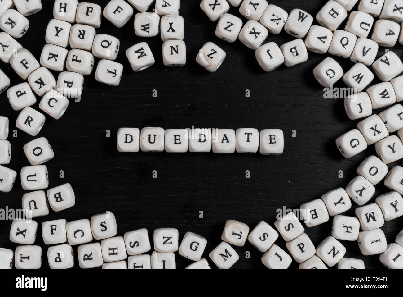 Word DUEDATE on wooden cubes on a black wooden table with copy space Stock Photo