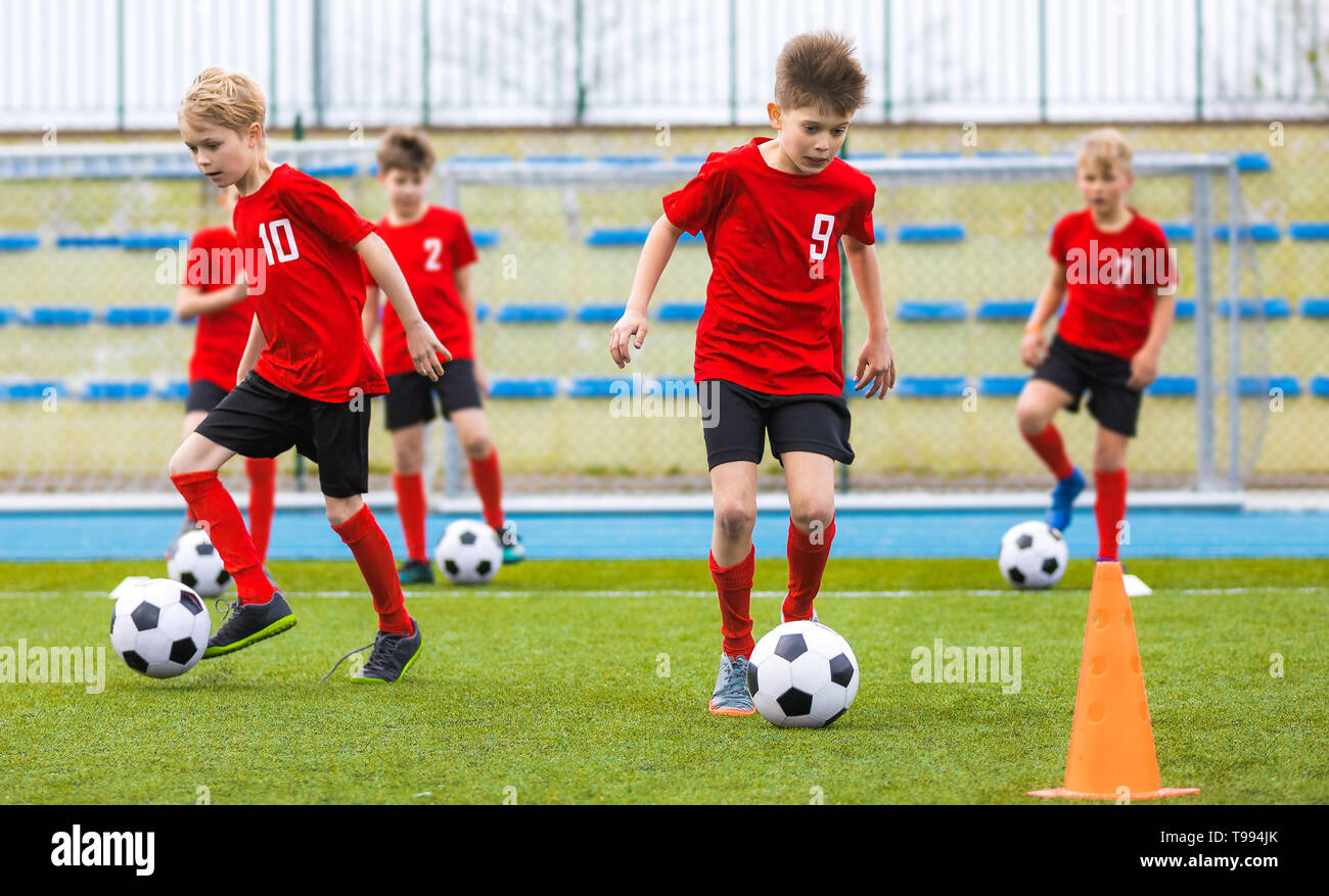 Boys training soccer skills on grass field. Football school class for children Stock Photo