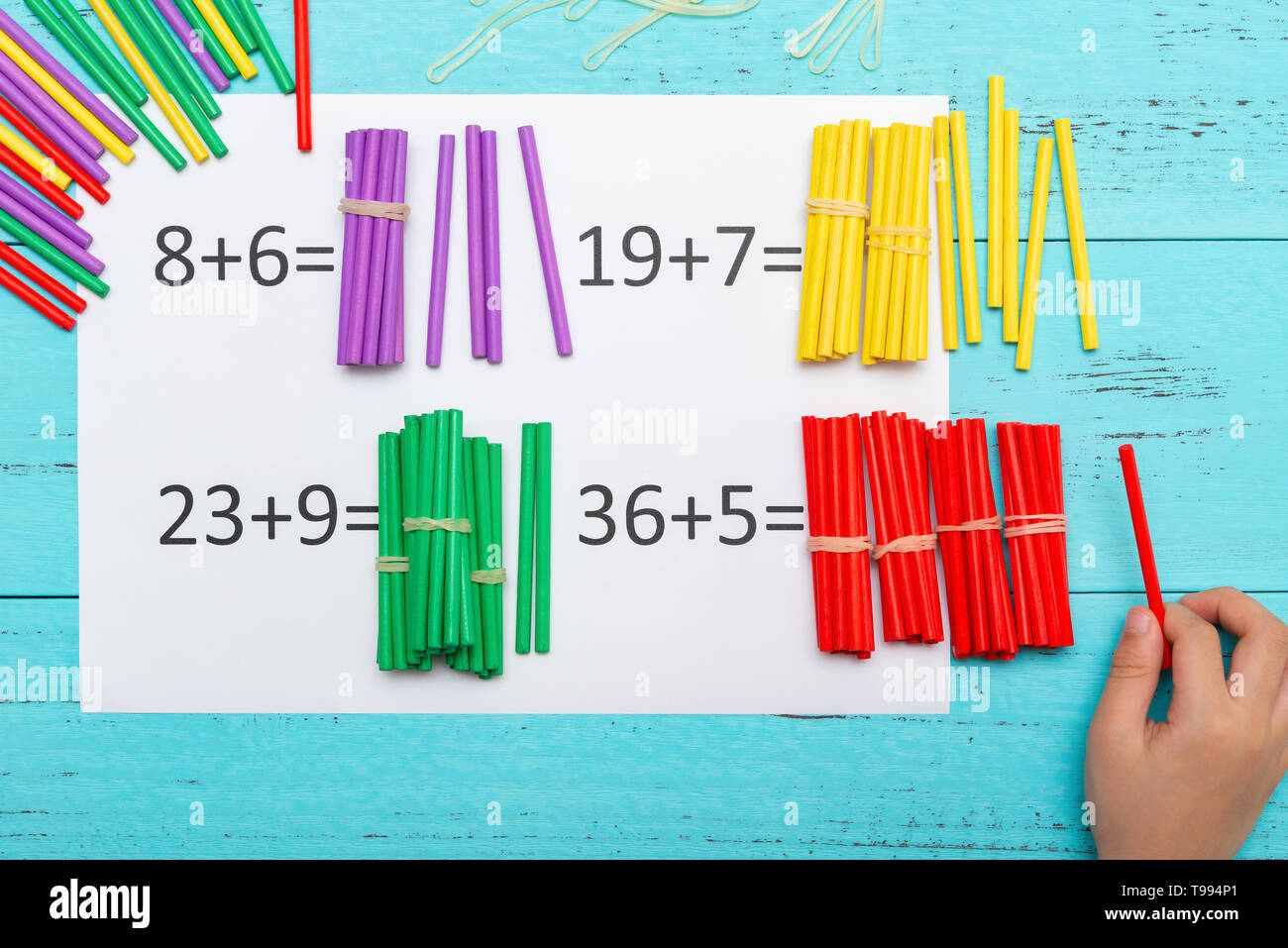 kid doing addition equations using counting rods Stock Photo