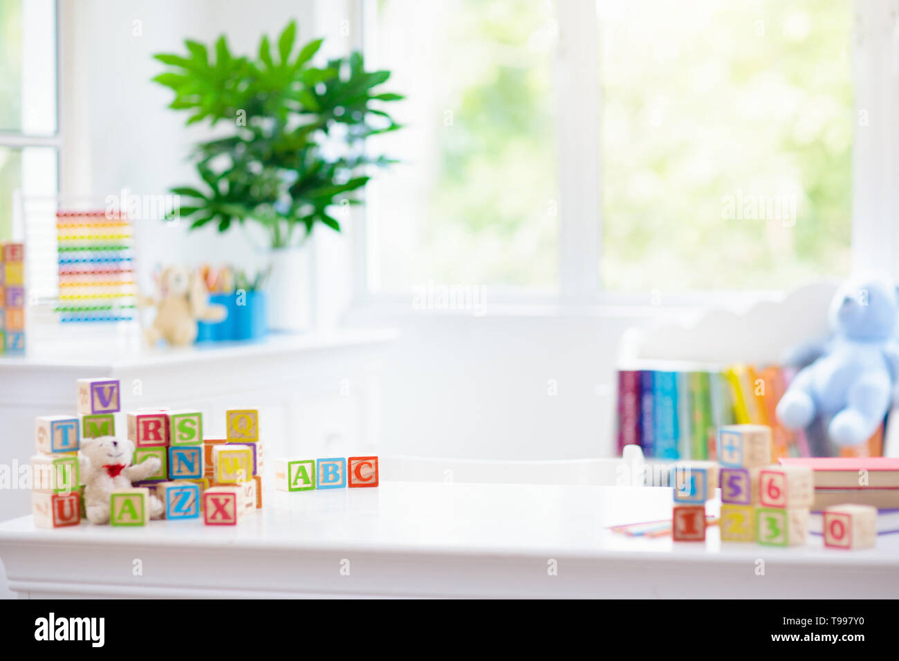 Child learning letters and numbers. Kid with colorful wooden abc blocks