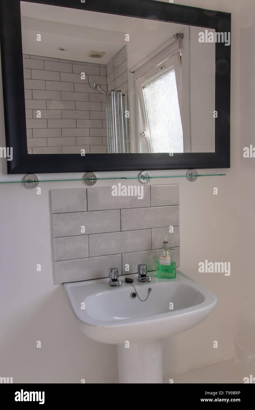 A Tiled Bathroom Sink With Mirror Above Stock Photo Alamy