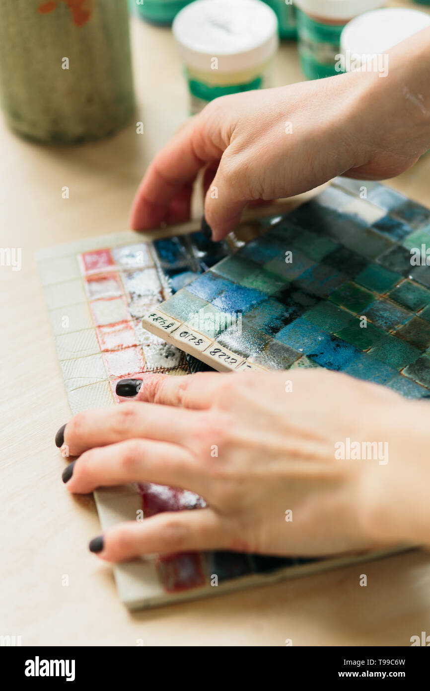 Potter holds the color palette glazes for coating ceramic products on