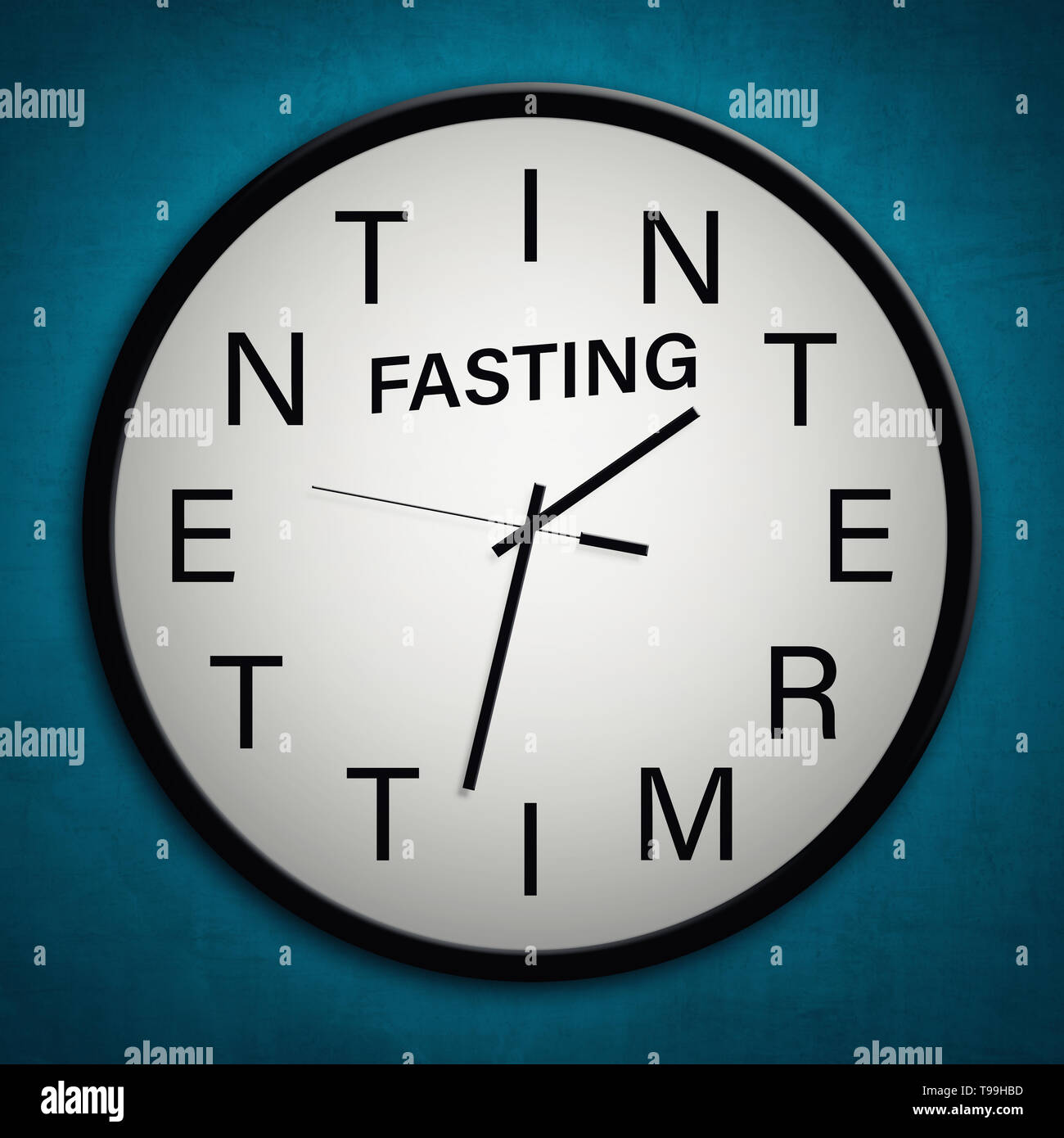 Intermittent fasting concept with words in clock hanging on blue wall Stock Photo